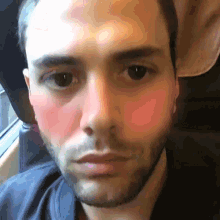 a close up of a man 's face with a beard and red cheeks