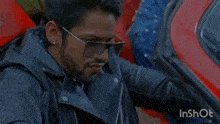a man is sitting in the driver 's seat of a car with his hand on his head .