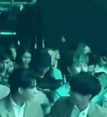 a group of people are sitting in a dark room in a club .