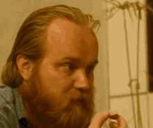 a man with a beard is looking at something