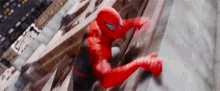 a man in a spiderman suit is climbing up a wall