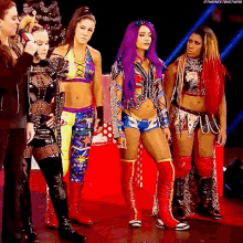 a group of female wrestlers are standing next to each other on a red carpet .