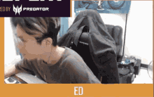 a man is sitting at a desk in front of a predator advertisement