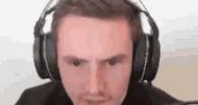 a man is wearing headphones and making a funny face .