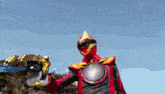a man in a red and black costume is holding a gun
