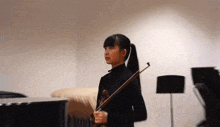 a young girl is playing a violin in a room