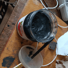 a jar of strawberry jam sits on a wooden surface