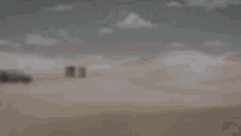 a blurry picture of two men standing next to each other in a desert .