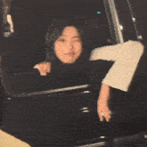a blurry picture of a woman sitting in a car .