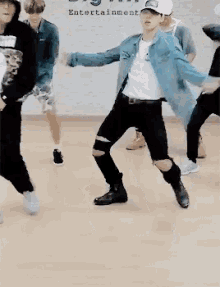 a group of people are dancing in front of a wall that says entertainment