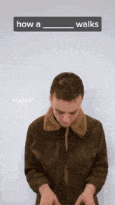 a man in a brown jacket is standing in front of a white wall with a sign that says how a walks