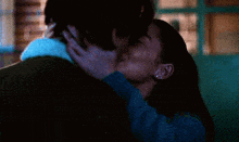 a man and a woman are kissing in front of a door that says ' a ' on it