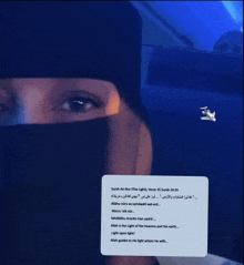 a woman wearing a black veil is holding a card that says ' sarah an-nur ' on it