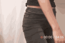 a woman is standing in front of a white curtain with a red circle that says 00:00
