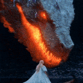 a woman in a white dress stands in front of a dragon