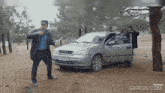 a man standing in front of a car with a license plate that says tc 937 kd