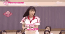 a girl is standing in front of a group of girls on a stage .