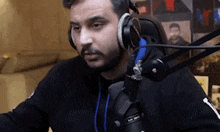 a man with a beard is wearing headphones and a microphone .