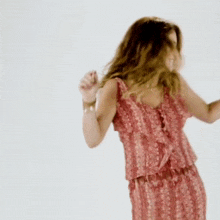 a woman in a red dress dancing with her hands in the air