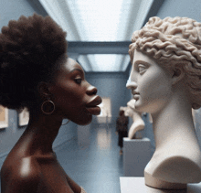 a woman looks at a statue of a woman 's head in a museum