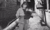 a woman in a suit is standing in an alley holding a hat