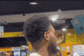 a man with a beard is standing in front of a sign that says ' juice '
