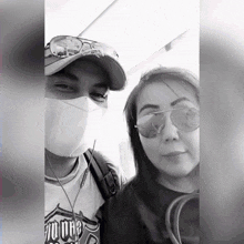 a man wearing a mask and a woman wearing sunglasses are posing for a picture