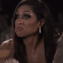 a woman in a white dress is making a face