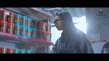 a person standing in front of a shelf of food with a logo that says ' tpm ' on it