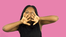 a woman wearing a black tank top is making a funny face with her hands