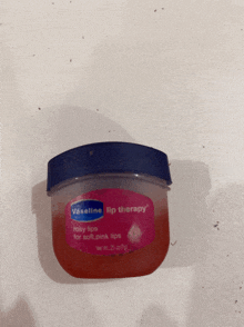 a jar of vaseline lip therapy is sitting on a white surface