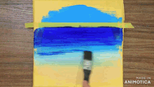 a person is using a brush to paint a blue and yellow landscape