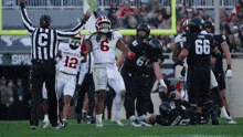 a football player with the number 6 on his jersey celebrates a touchdown