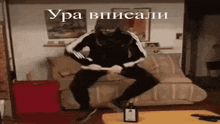 a man is sitting on a couch with a bottle of alcohol on a table