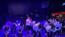 a group of people are dancing in front of a screen that says xk