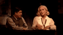a man and a woman are sitting next to each other in a dark room .