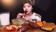 a woman is sitting at a table eating various foods
