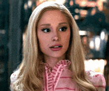 a close up of a woman 's face wearing a pink dress
