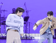 a man wearing a sweater that says borderless freemind is dancing with another man