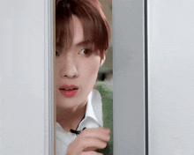 a close up of a person looking out of a doorway .
