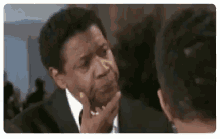 a man in a suit and tie is making a funny face .