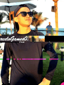 a man wearing sunglasses and a black shirt that says reels gamesq