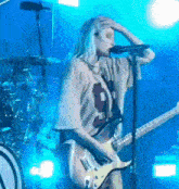 a woman is singing into a microphone while holding a guitar .