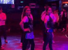 a group of people are dancing in a dark room and one of them is wearing a jersey that says ' wolves ' on it