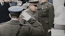 a man in a military uniform salutes a man in a blue hat