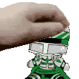 a hand is holding a toy robot with a green and white helmet on .