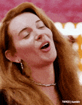 a woman with red hair is making a funny face with her mouth open .