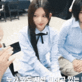 a girl with long hair wearing a blue shirt with a black tie