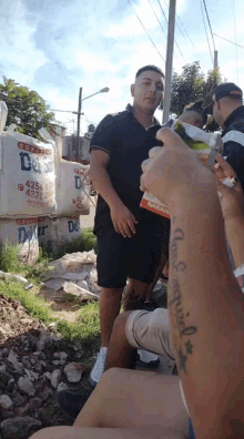 a man with a tattoo on his arm holding a bottle