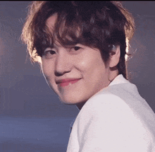 a close up of a young man 's face with a smile on his face